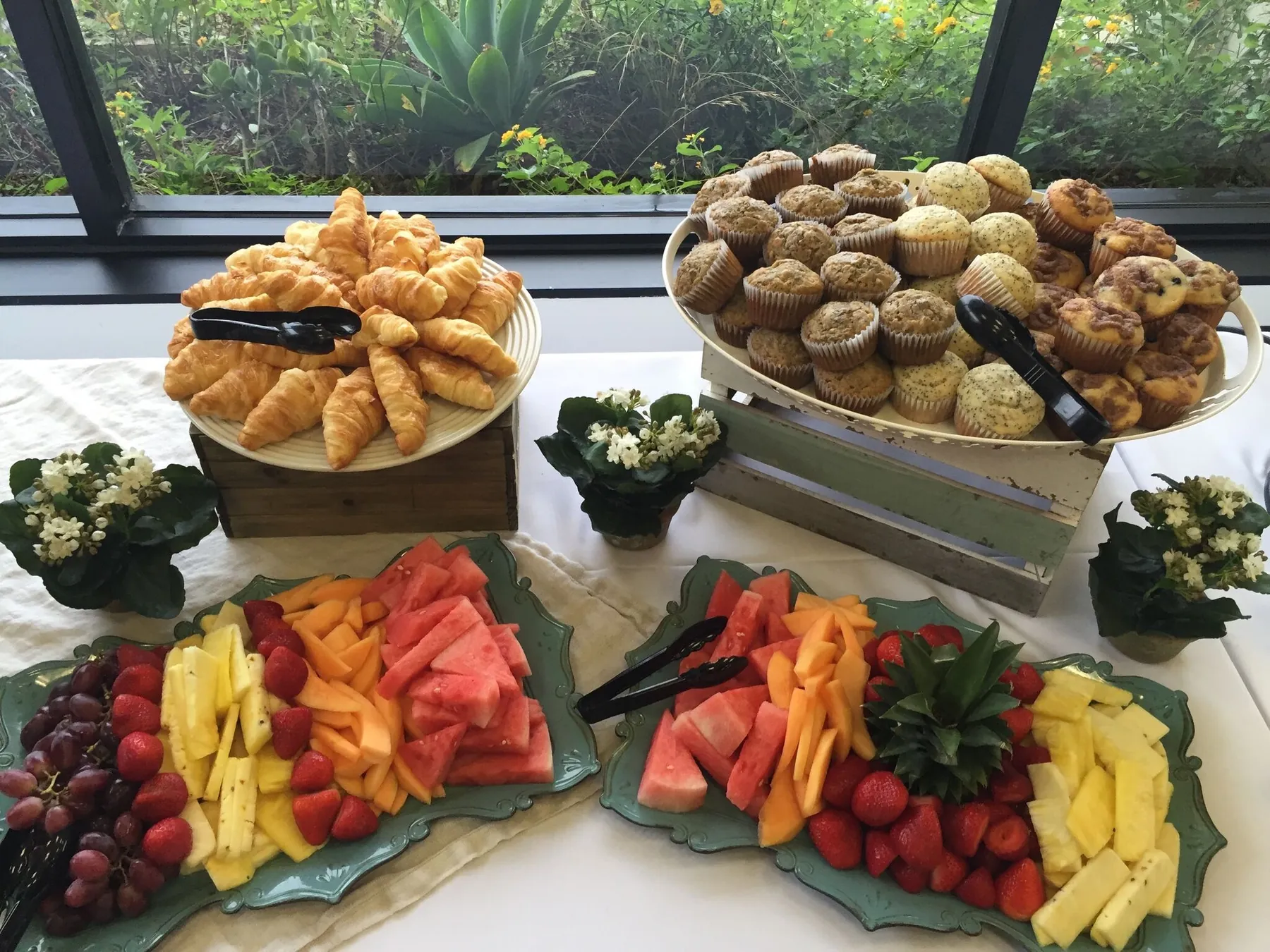 Breakfast catering spread with croissants, muffins and fresh fruit platters